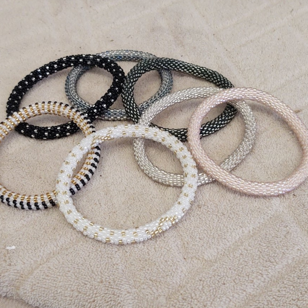 Seven handmade beaded bracelets in metallic colors